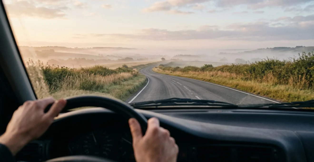 Conducteur au volant regardant loin devant sur une route dégagée au lever du jour, symbolisant l'anticipation et la vigilance